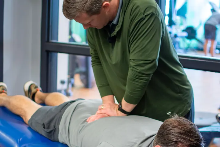 Hands-on low back treatment with a patient lying face down at ALTR Performance & Physical Therapy